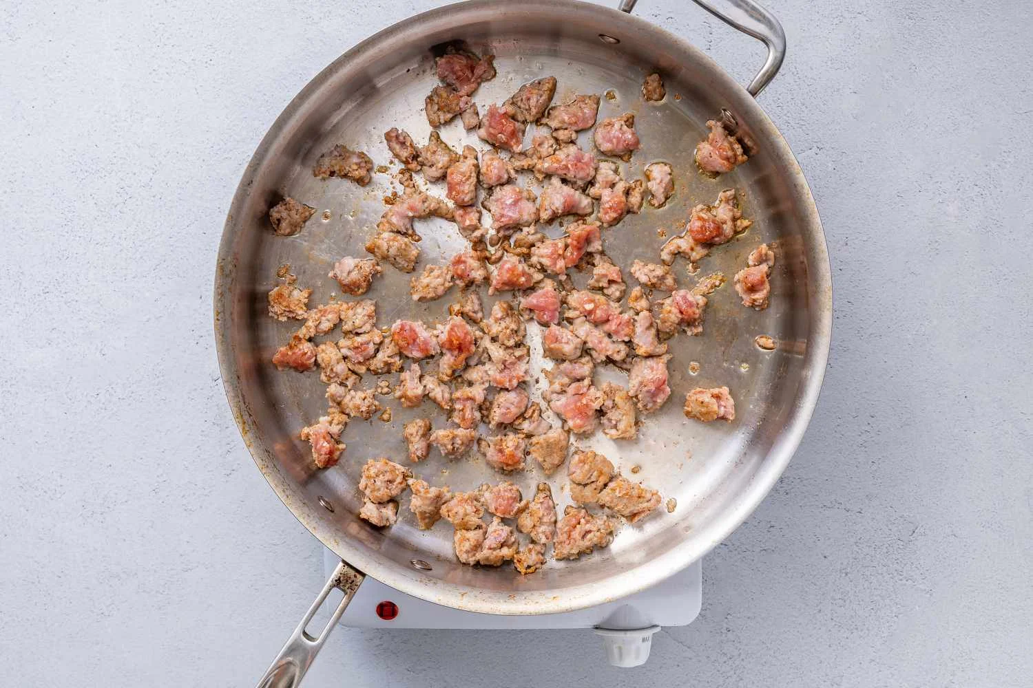 Sausage cooking in a large pan