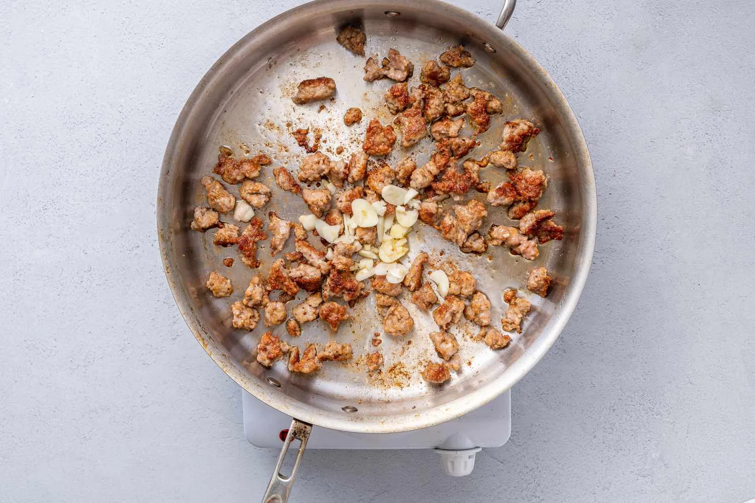 Garlic and chili flakes added to the pan with sausage