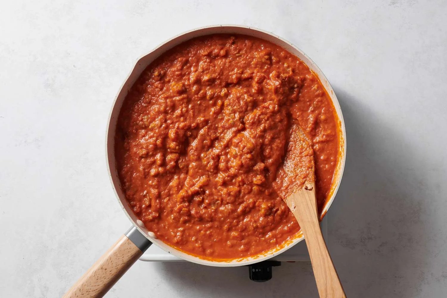 Vodka sauce added to the sausage mixture in a pan