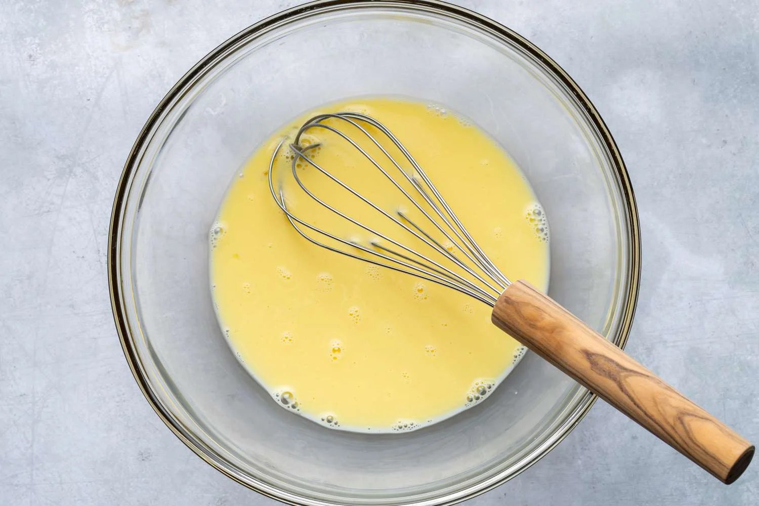 A bowl of whisked milk, eggs, and salt