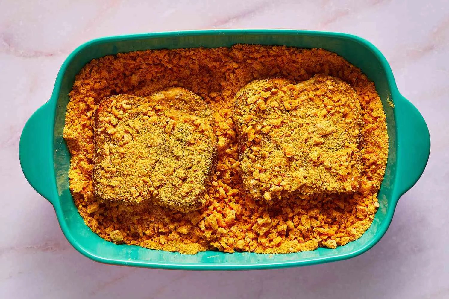 Two pieces of soaked bread coated in crushed cereal