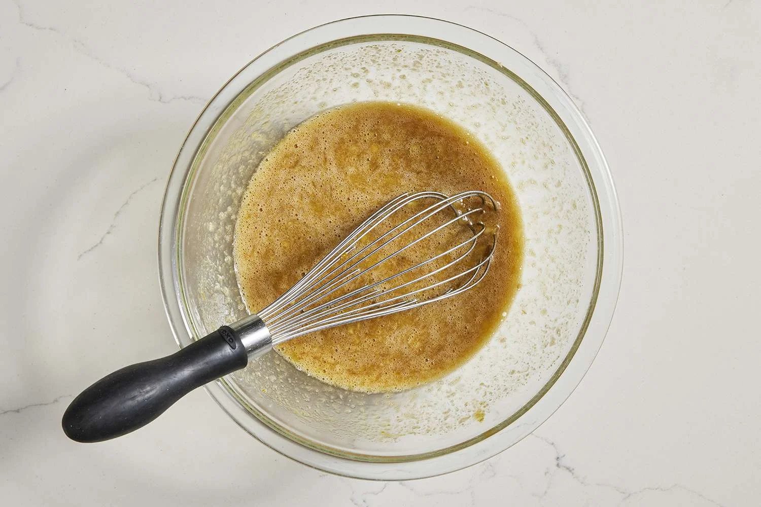 wet ingredients for pumpkin banana bread in bowl with whisk