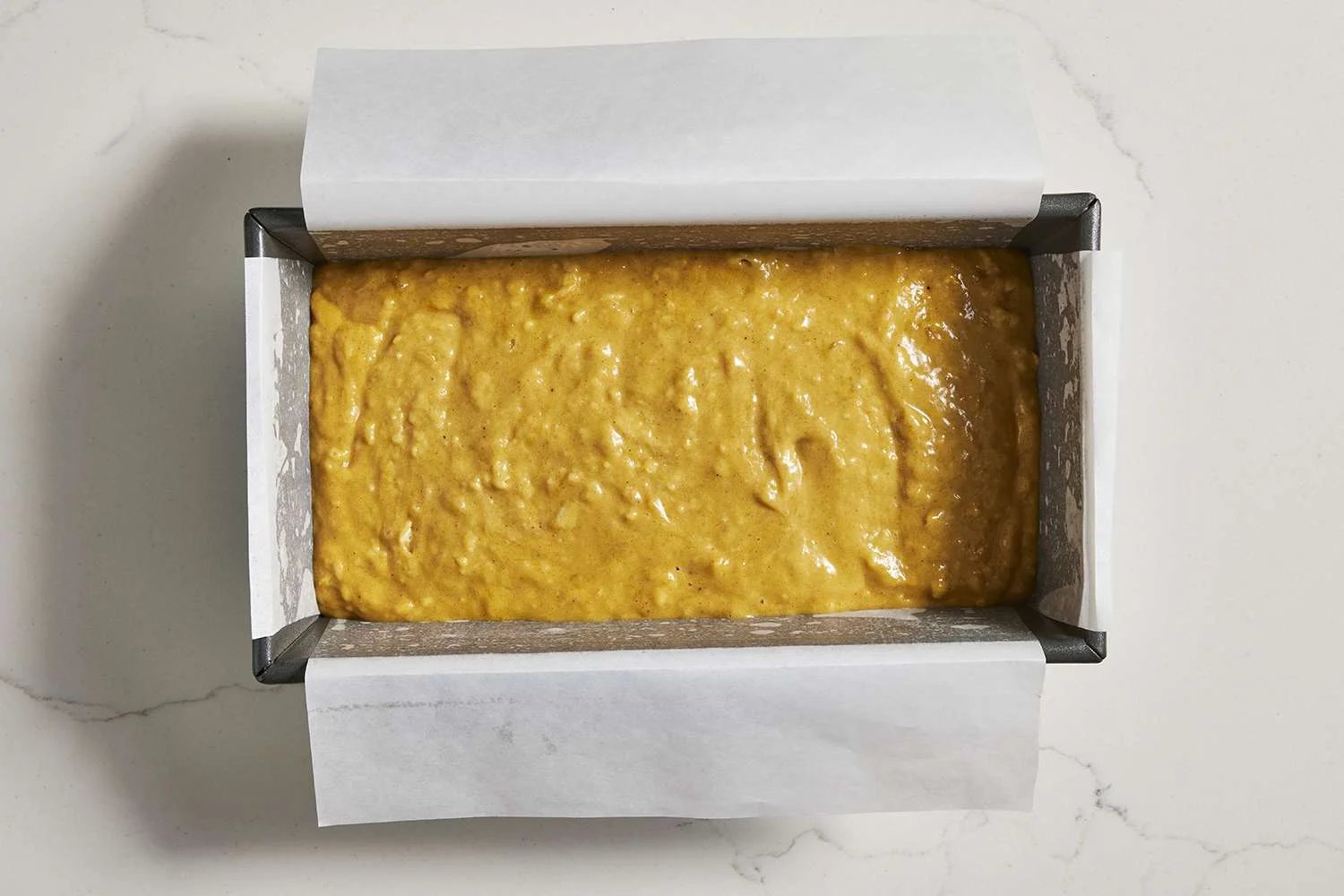 loaf pan filled with pumpkin banana bread batter