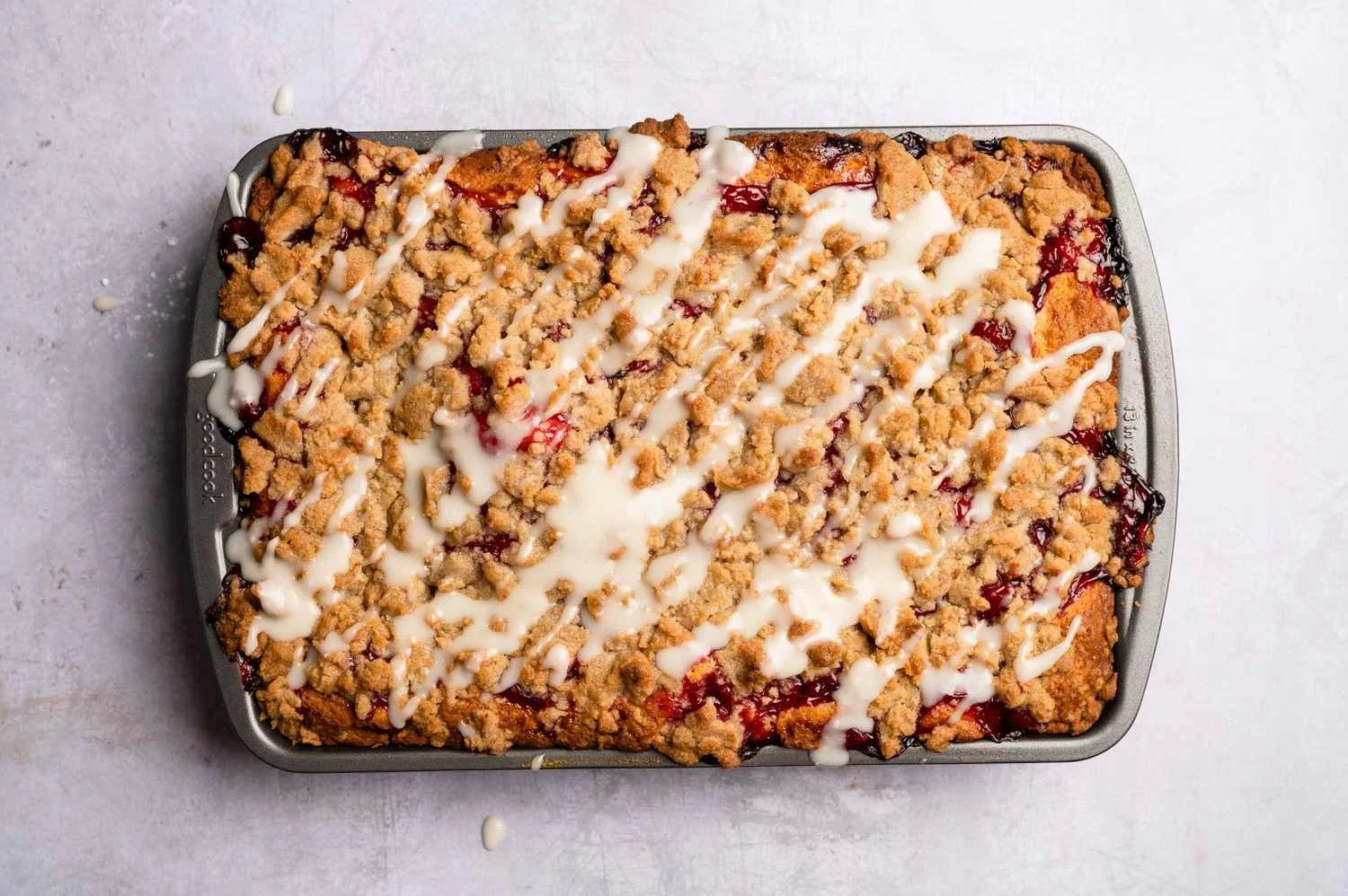 A cooked cherry coffee cake topped with icing