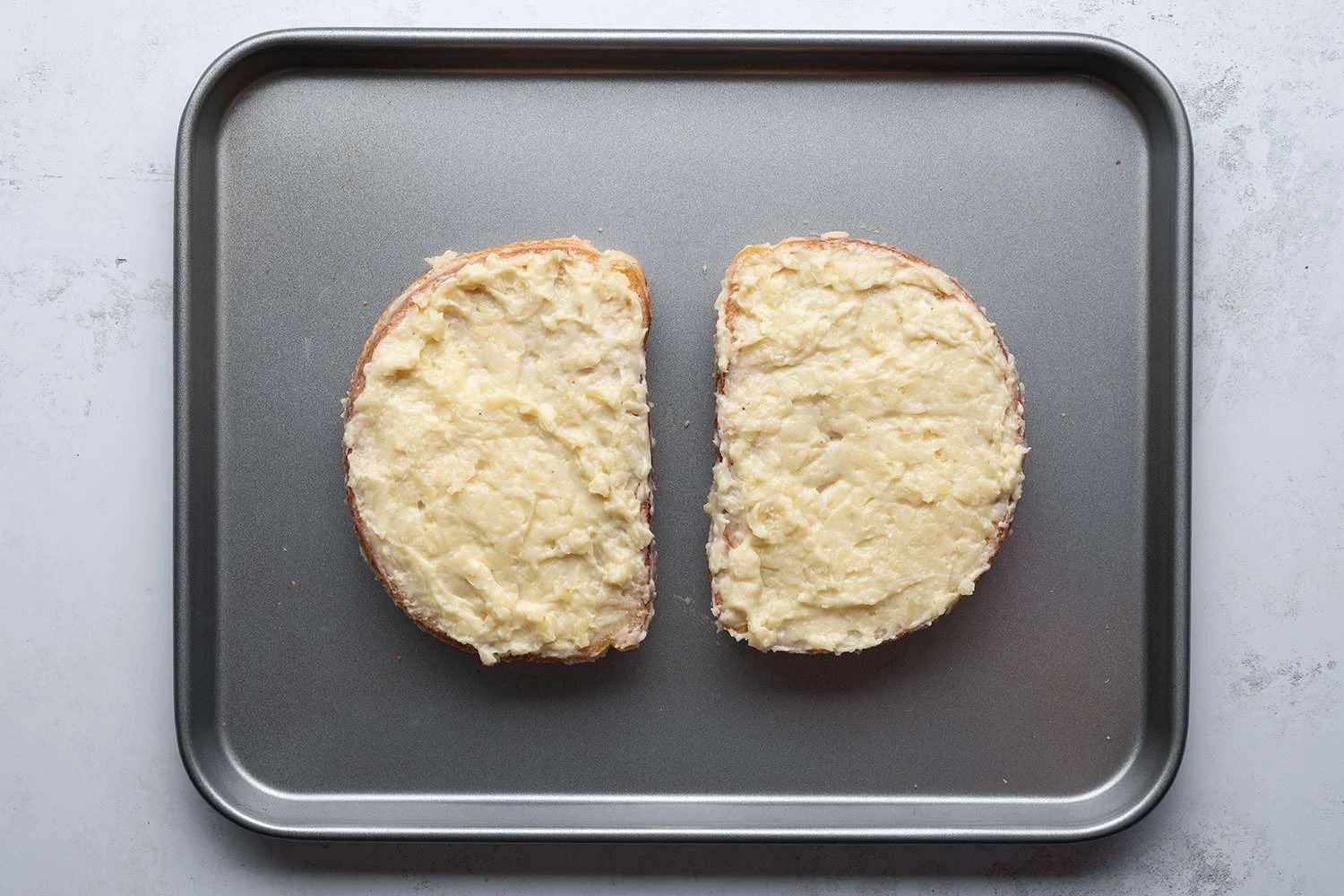 Sandwiches with cheese sauce on a baking sheet